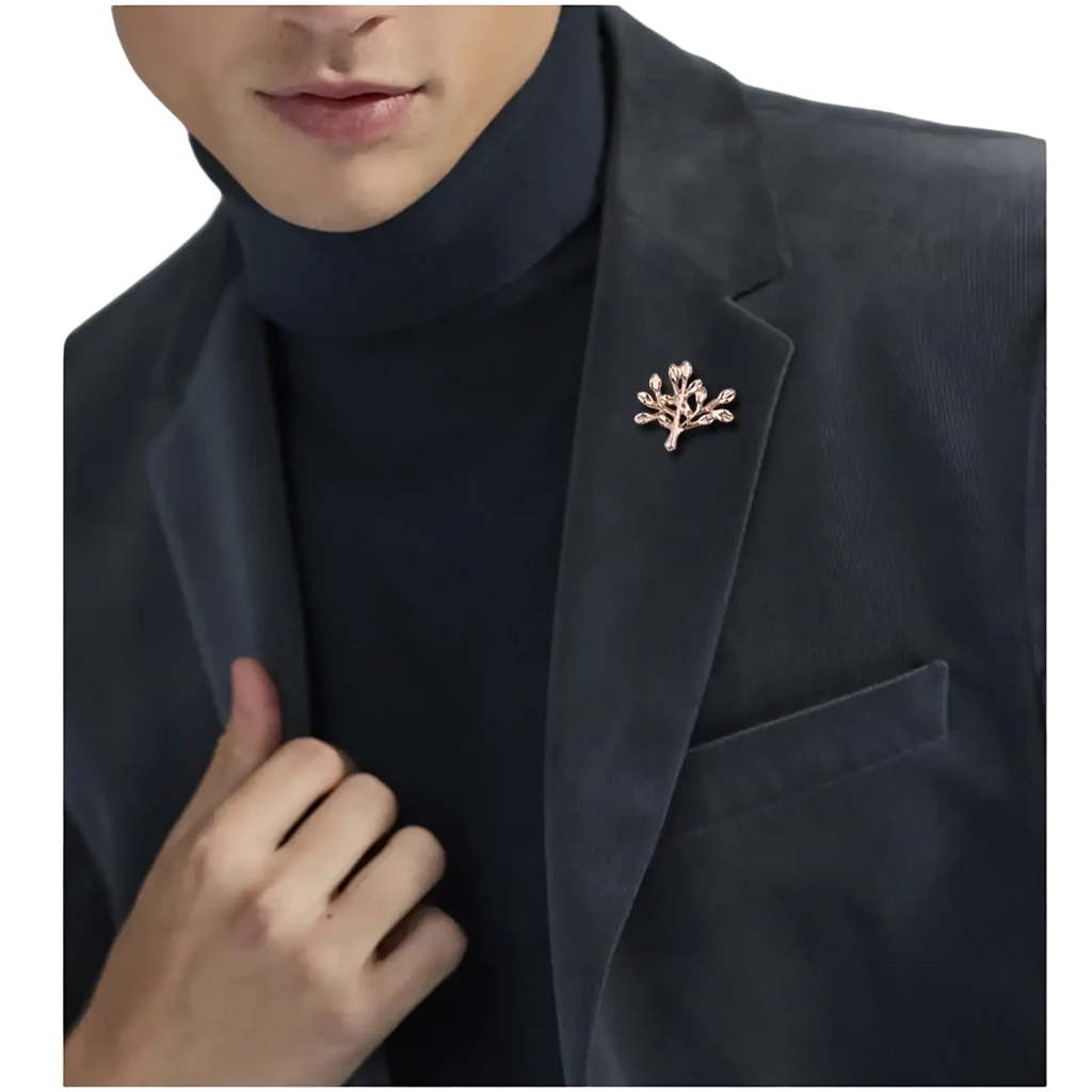 Delicate rose gold metal tree-shaped anchor lapel pin with sparkling stones pinned to dark velvet men’s blazer