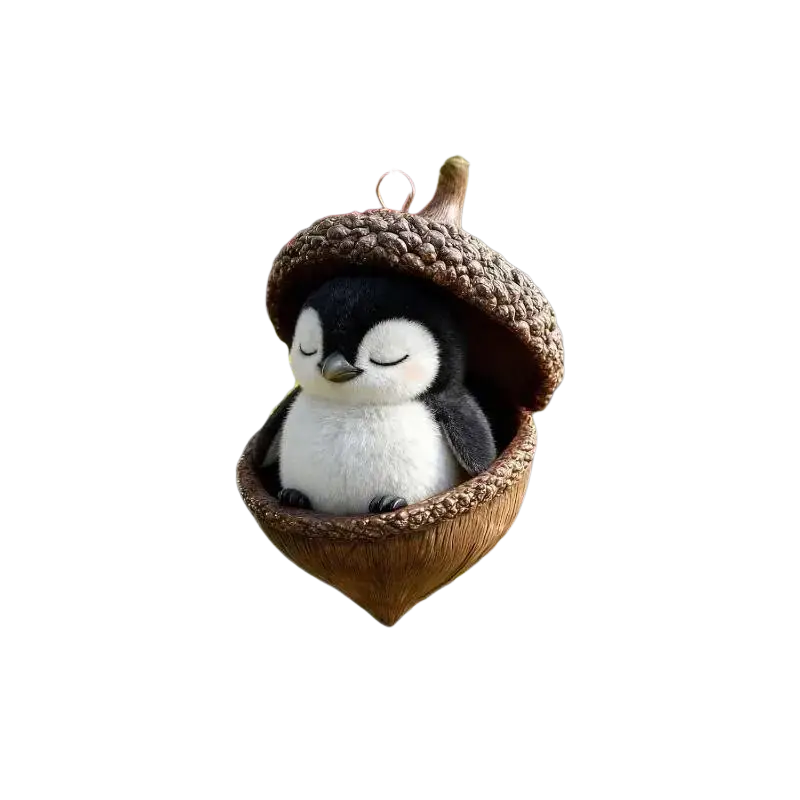 Adorable plush black and white penguin nestled inside a brown acorn animal christmas ornament for christmas tree decor