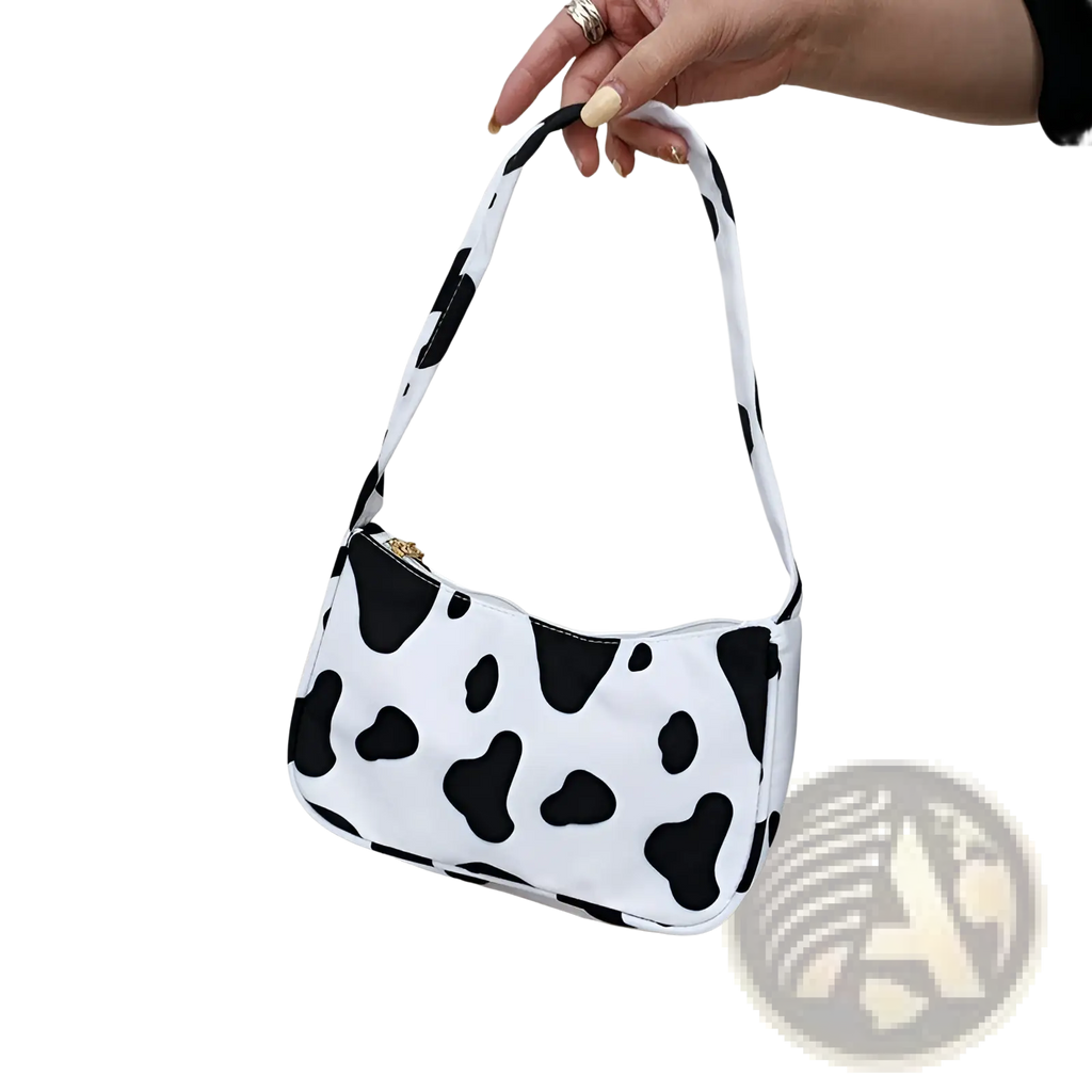 Animal print underarm shoulder bag for women in white with black cow print pattern and gold-tone zipper closure