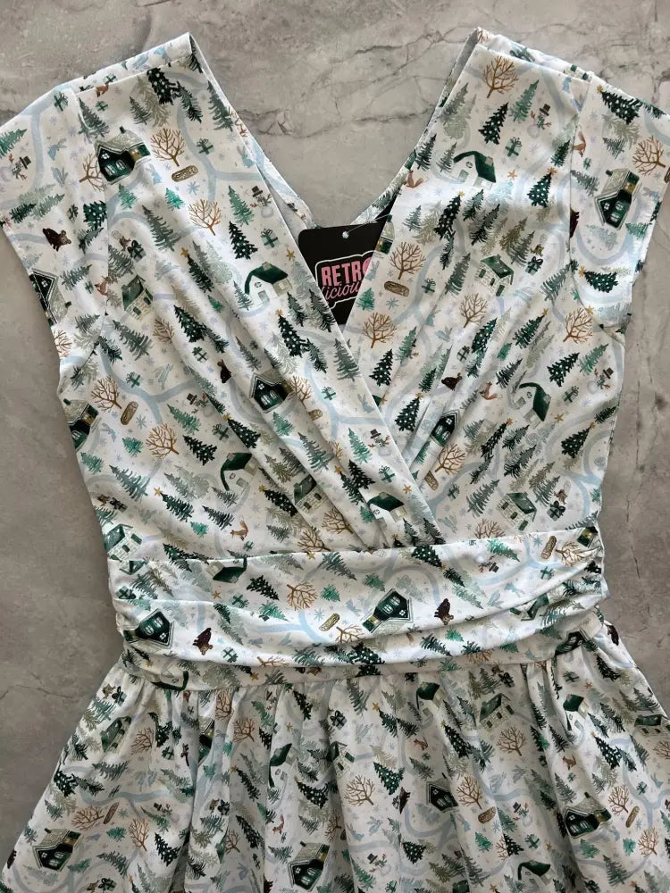 Animal Town Greta V-neck cotton holiday dress in white with festive forest print of pine trees leafless trees and cabins