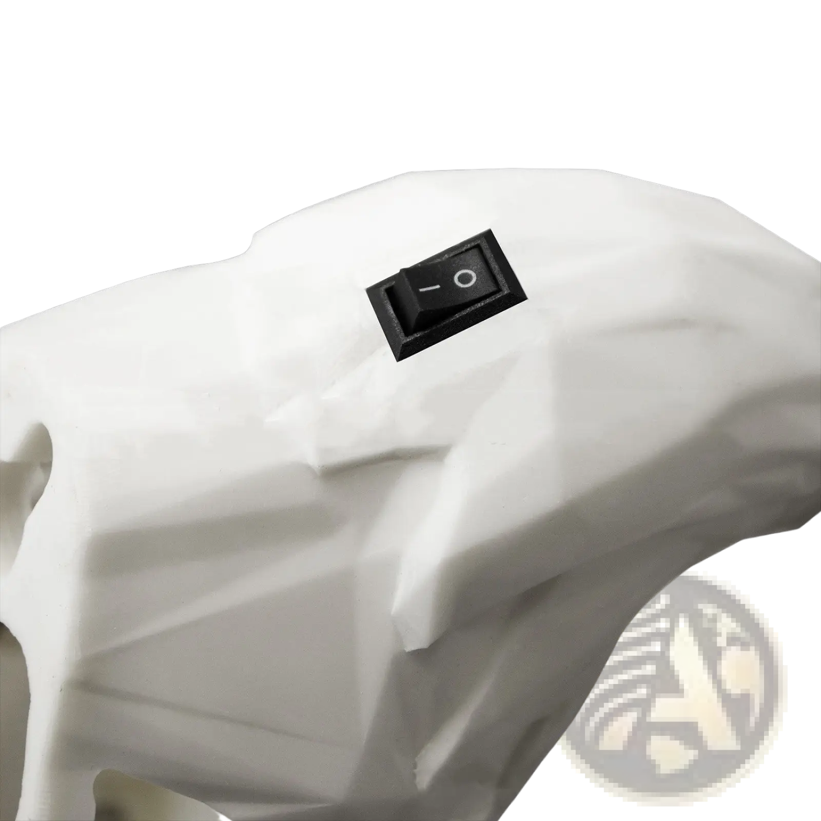 White geometrically faceted skull-shaped 3d printed animal wall lamp with a black toggle switch on its forehead