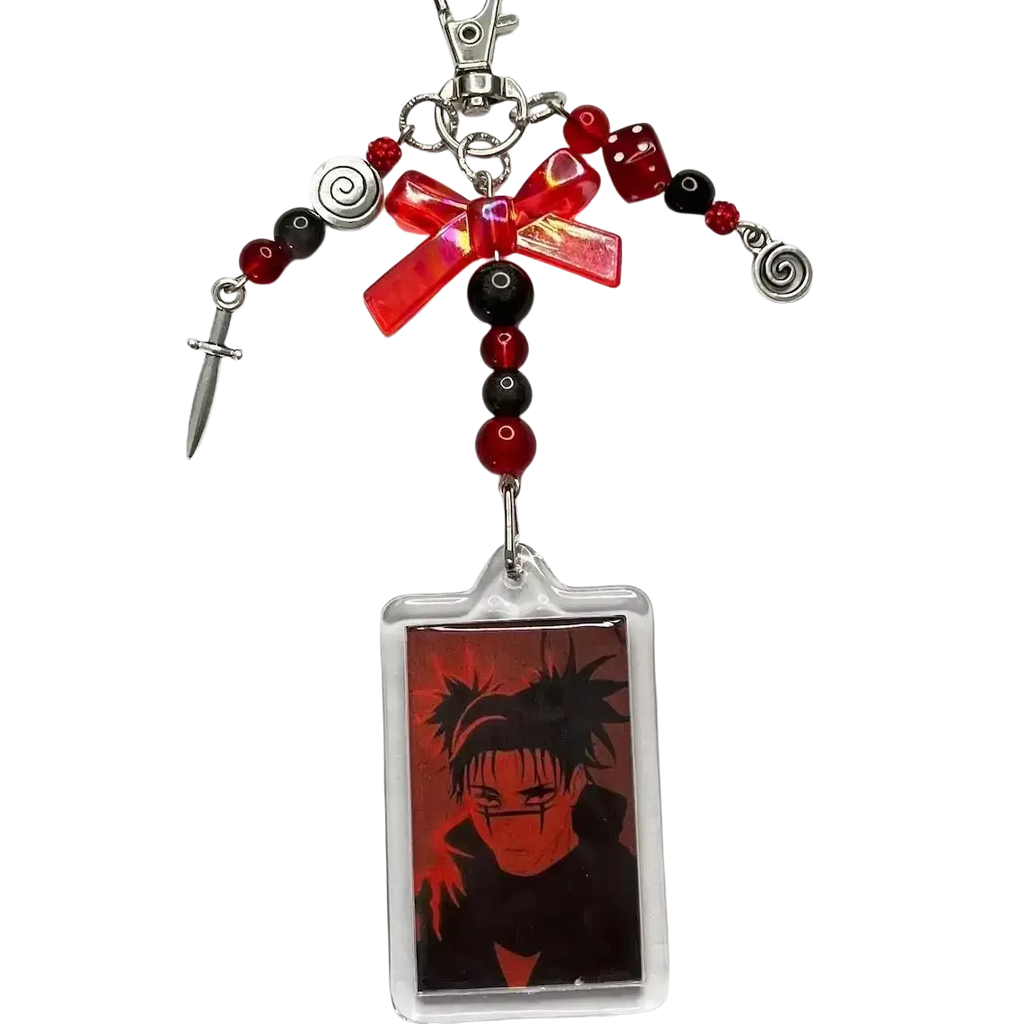 Anime beaded y2k acrylic keychain featuring red and black beads, translucent red bow, silver spiral charms, dice, dagger, and anime portrait