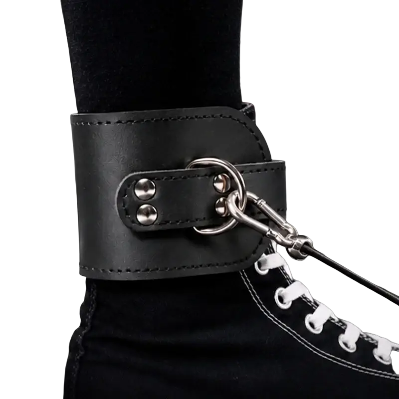 Black leather ankle strap with silver metal hardware and chain attachment for cable machine strength training