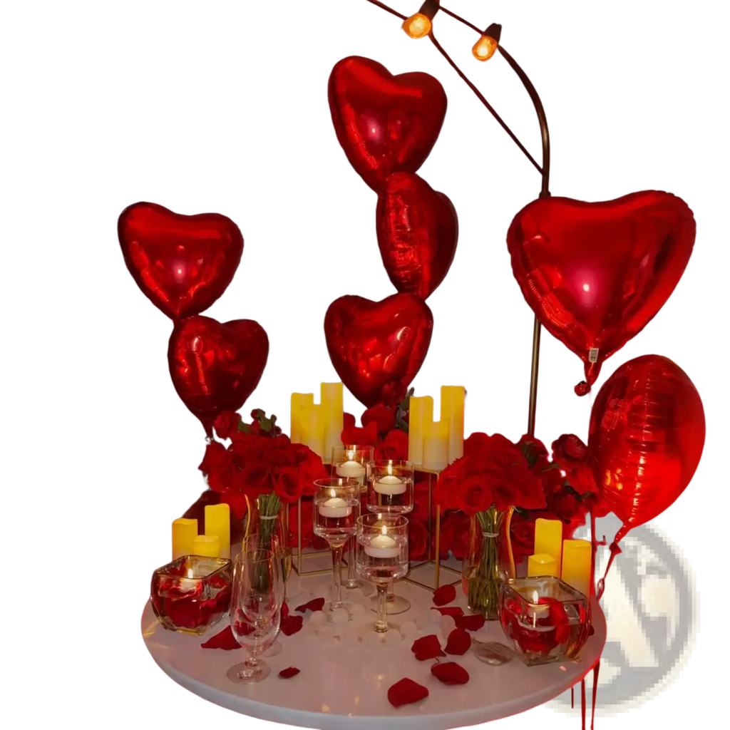 Red metallic heart-shaped balloons from anniversary decoration set with rose petals for romantic celebrations