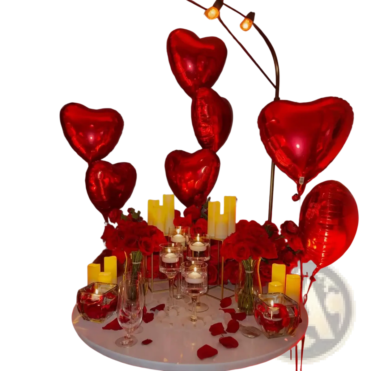 Red metallic heart-shaped balloons from anniversary decoration set with rose petals for romantic celebrations