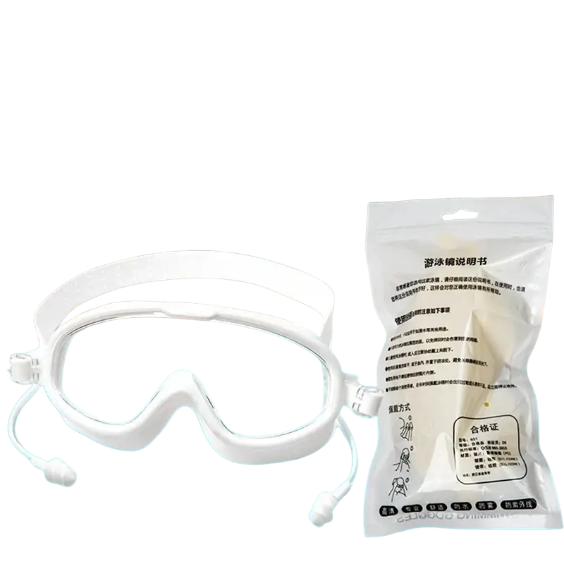 White anti-fog swimming goggles with clear lenses and adjustable silicone straps in plastic packaging beside pool