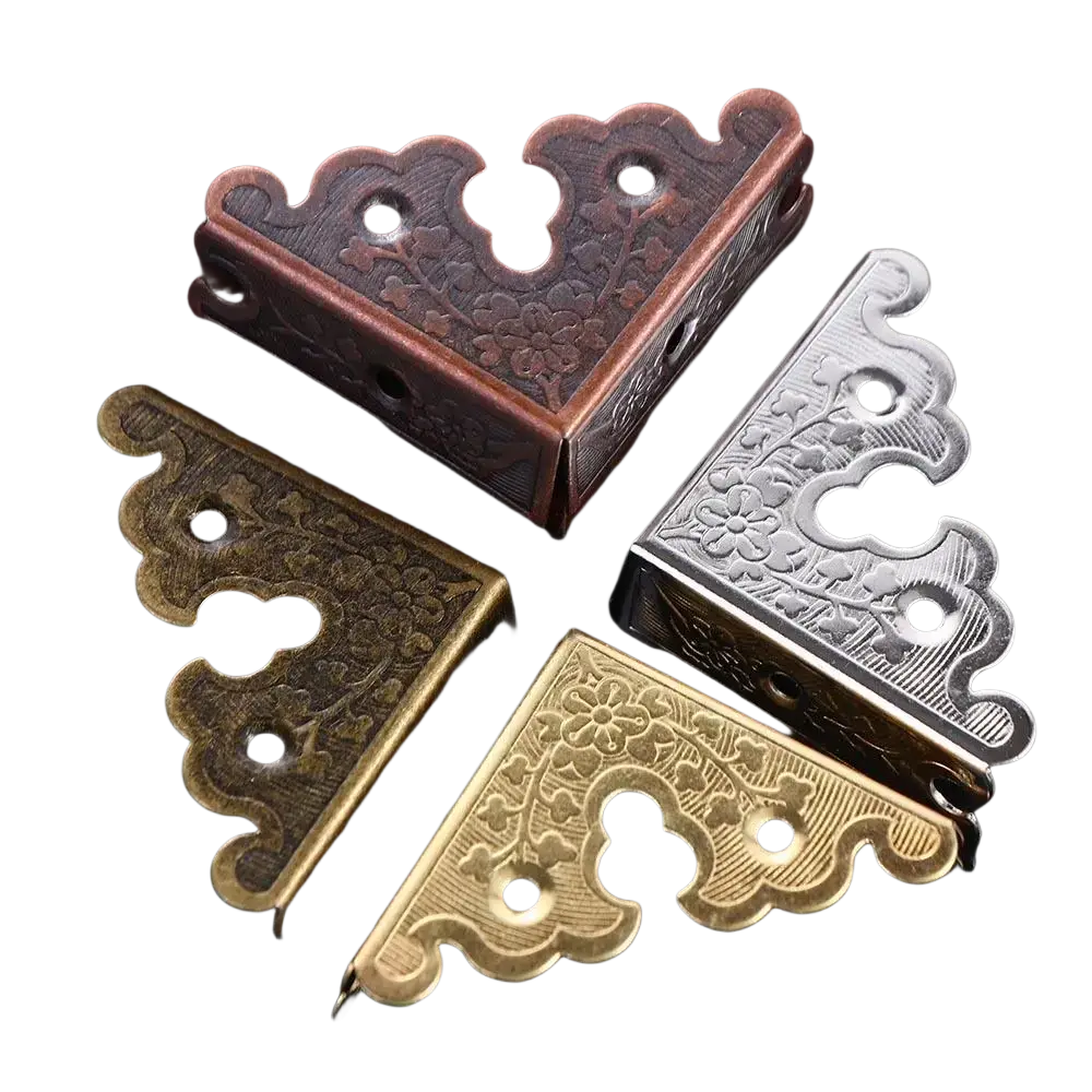 Antique bronze decorative corner brackets in metal with intricate floral engravings as furniture protector accessories