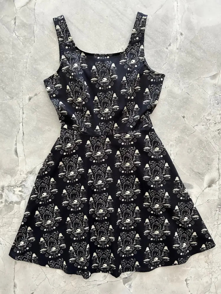 Black sleeveless a-line skater dress with white botanical and mushroom apothecary print for casual wear