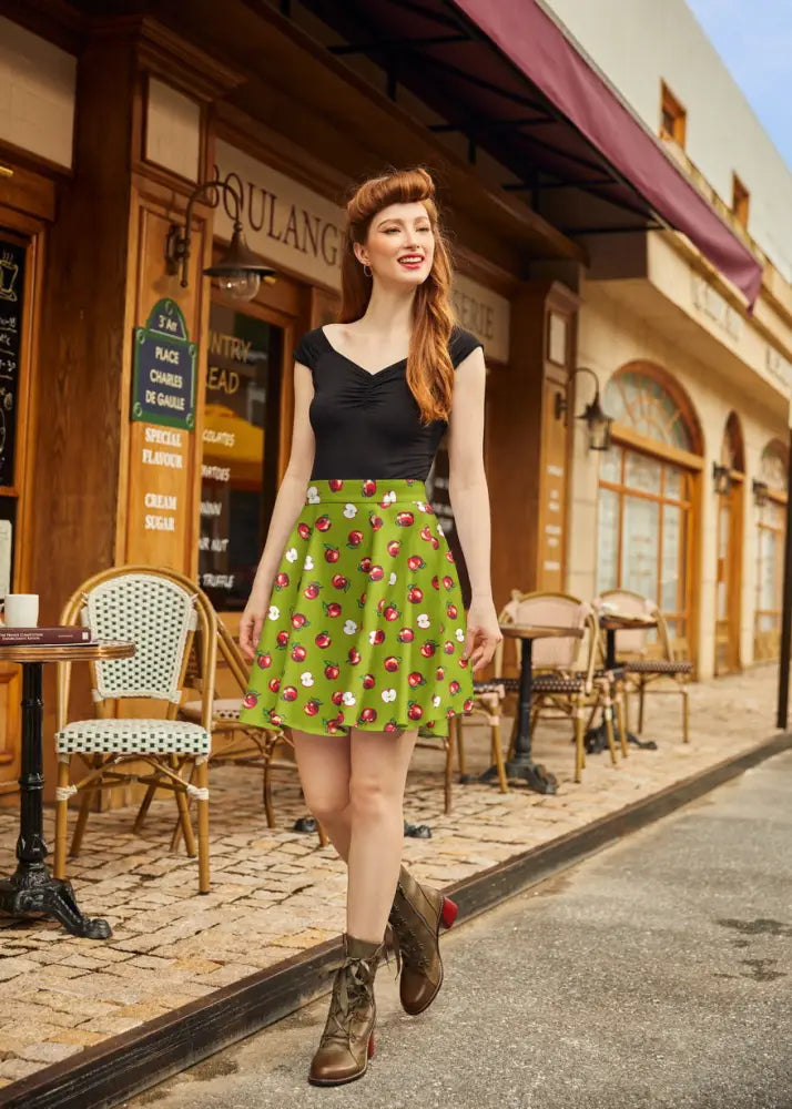 Green pleated skater skirt with apple print featuring an a-line silhouette and lightweight fabric for casual wear