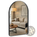 Arched wall mirror with sleek black metal frame reflecting a cozy living room scene for modern vanity use