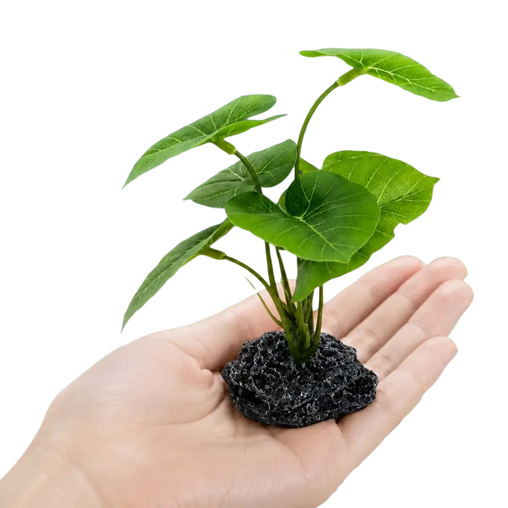 Artificial aquarium plant with broad green foliage rooted in black porous lava rock weighted base