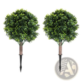 Two artificial boxwood ball topiary trees with vibrant green foliage and brown stems mounted on black metal spikes
