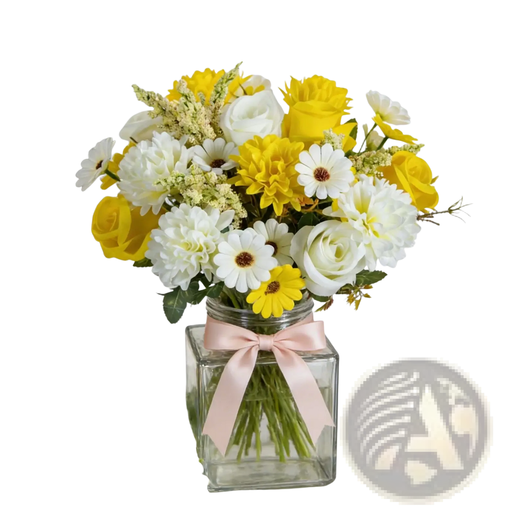 A clear square glass vase with a pink satin ribbon holding a yellow and white artificial flower wedding bouquet
