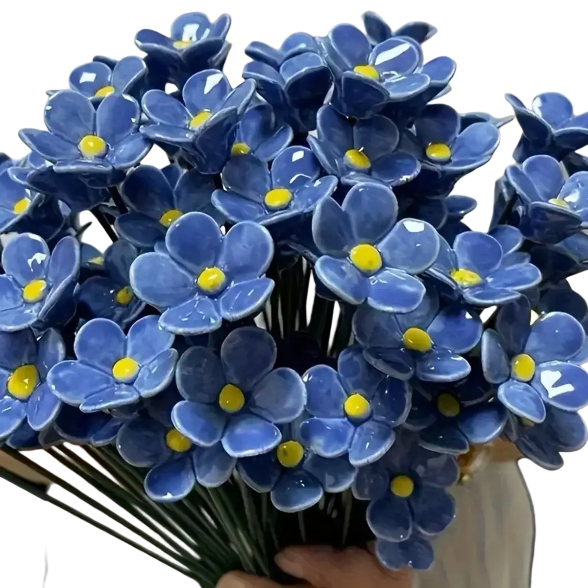 A bouquet of glossy blue ceramic artificial flowers with yellow centers ideal for decorating vases