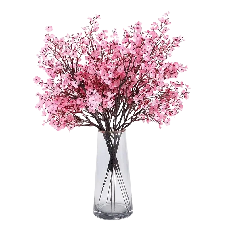 A bouquet of artificial flowers cherry blossoms in pink arranged in a clear glass vase for decorative use
