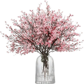 A delicate pink artificial flowers cherry blossoms bouquet arranged in a clear ribbed glass vase