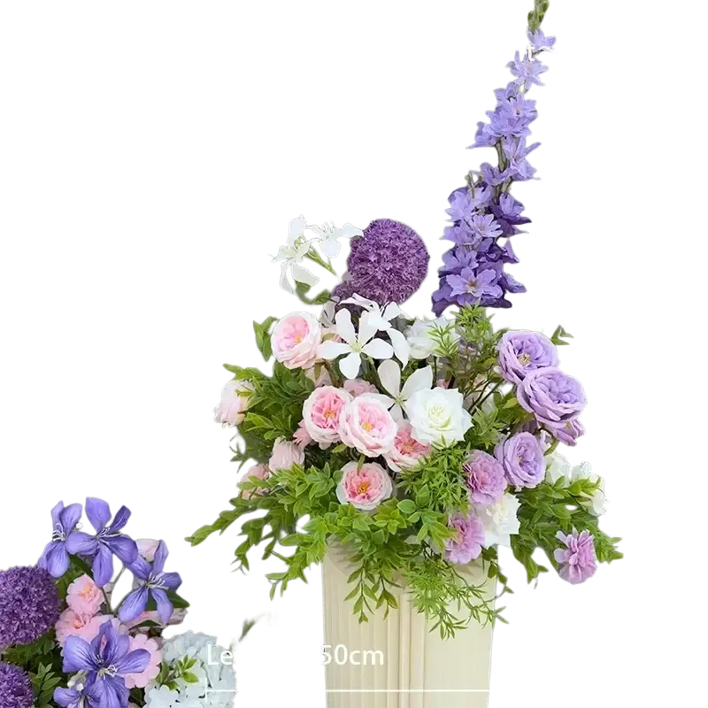 A tall cream-colored vase with vertical fluting holds artificial flowers in purple pink and white for wedding arch decor