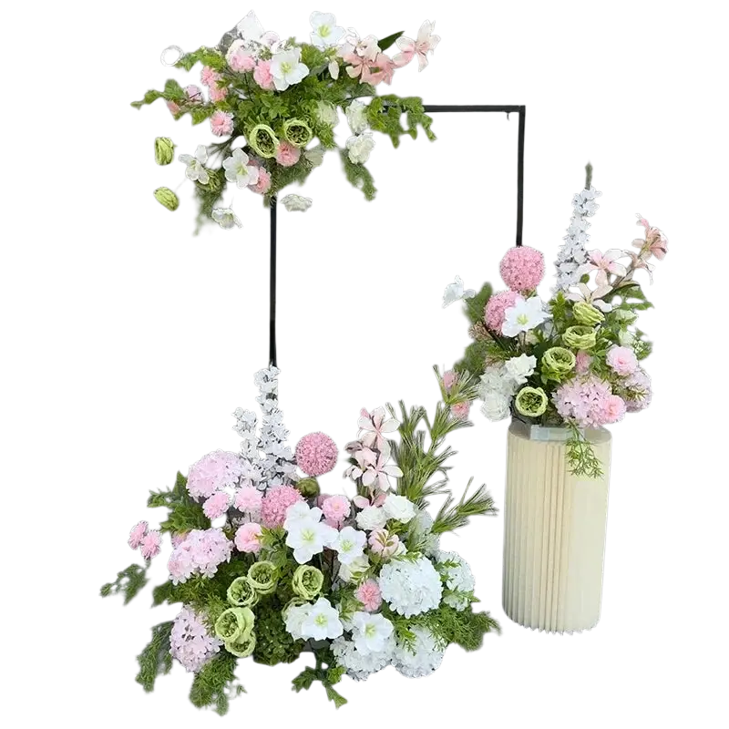 A tall cream-colored pleated vase with artificial flowers in pink white and green for wedding arch backdrop