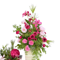 A vibrant artificial flowers wedding arch floral backdrop featuring pink and deep red roses in a cream vase