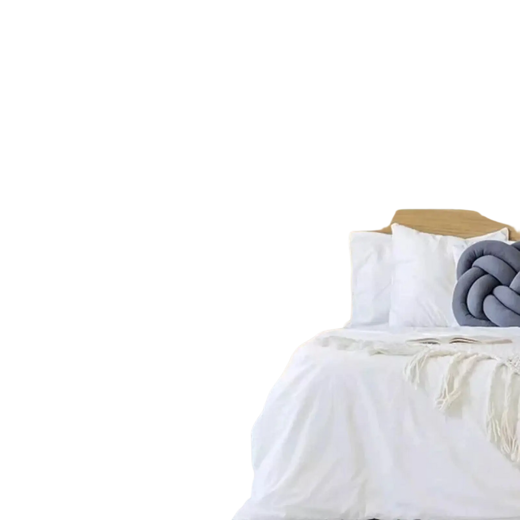 Wooden bed with white bedding and gray knotted pillow next to artificial hanging plants 4 pack fake ivy vine decor