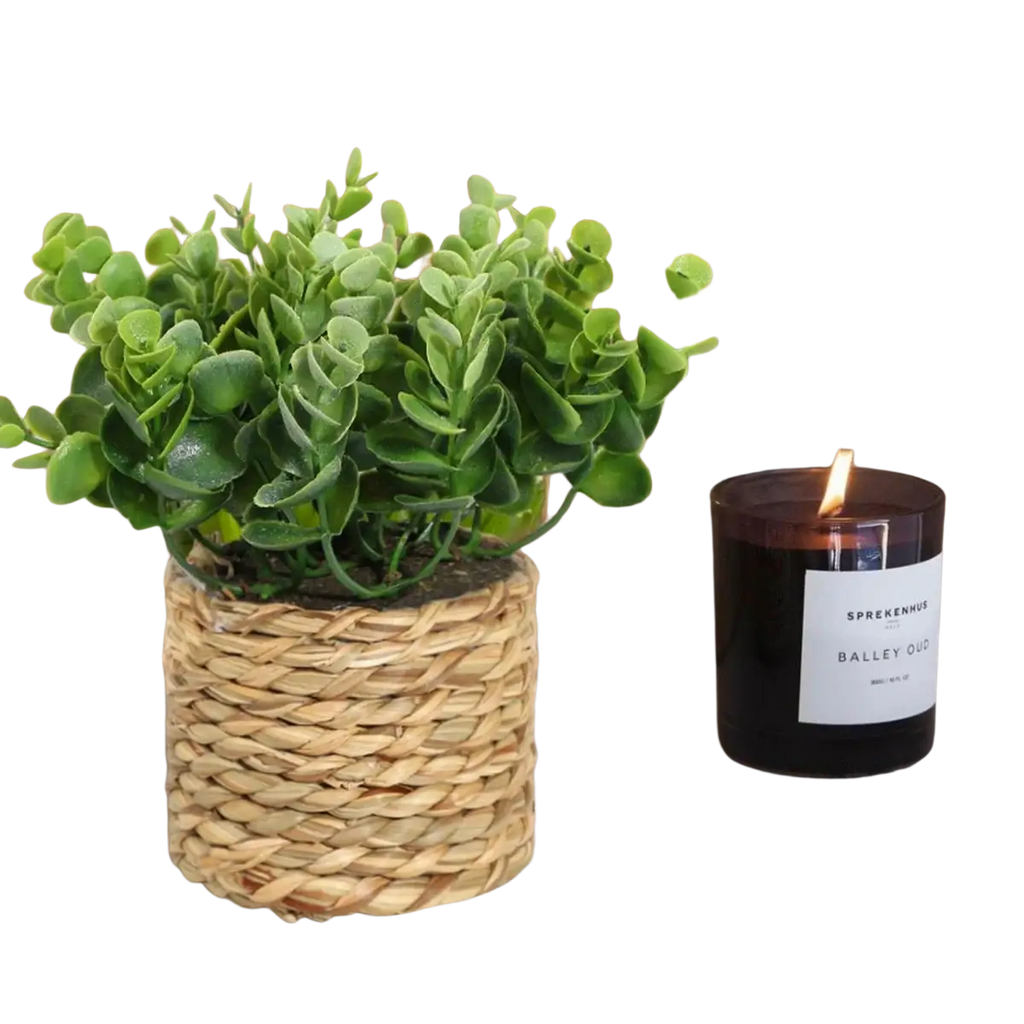 A small potted artificial plant featuring vibrant green eucalyptus flowers in a woven natural fiber planter