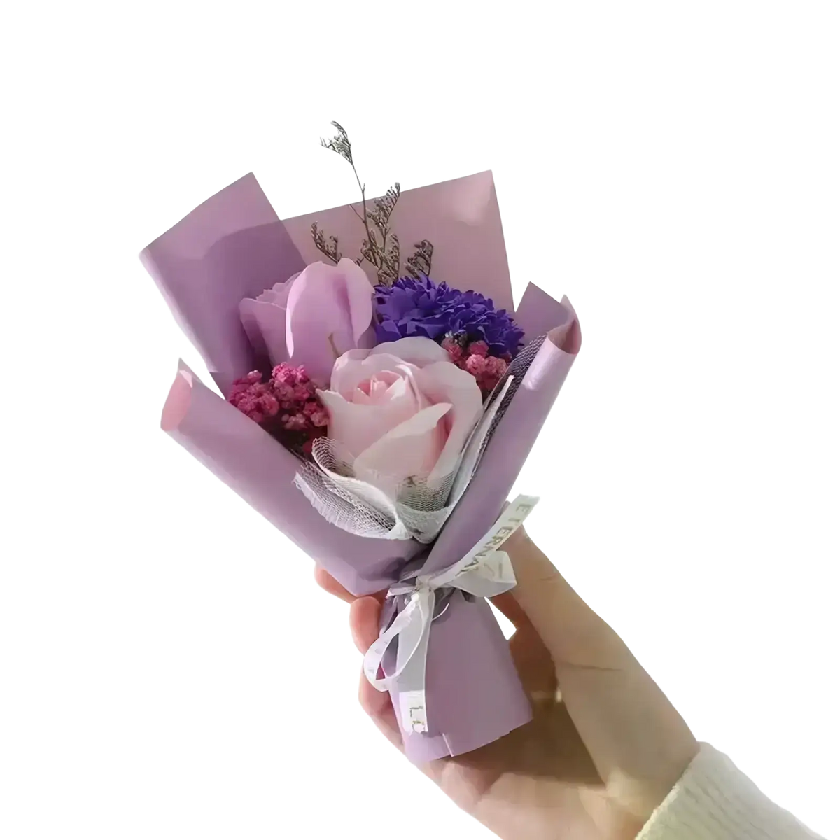 Artificial rose flower bouquet wrapped in lavender featuring a soft pink rose and purple blooms tied with white ribbon