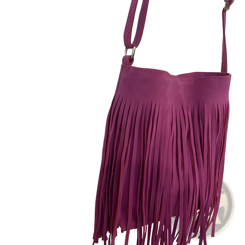 A vibrant magenta suede fringe crossbody bag with silver hardware for travel in the artistic tassel canvas collection