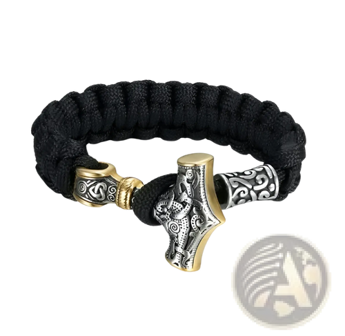 Black paracord bracelet with an engraved silver mjolnir charm featuring silver and gold-toned metallic accents