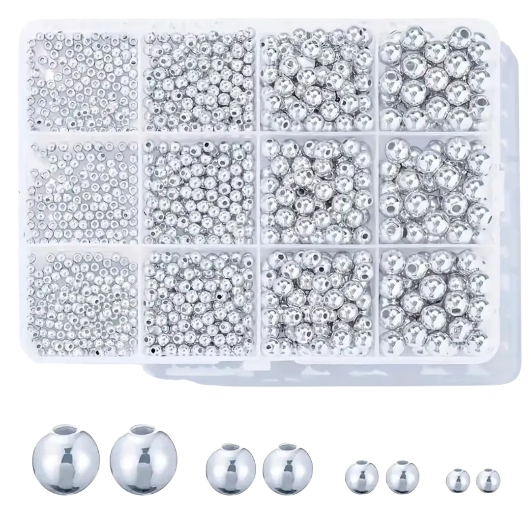A clear plastic organizer box with assorted silver metallic round beads and individual bead samples for diy jewelry making