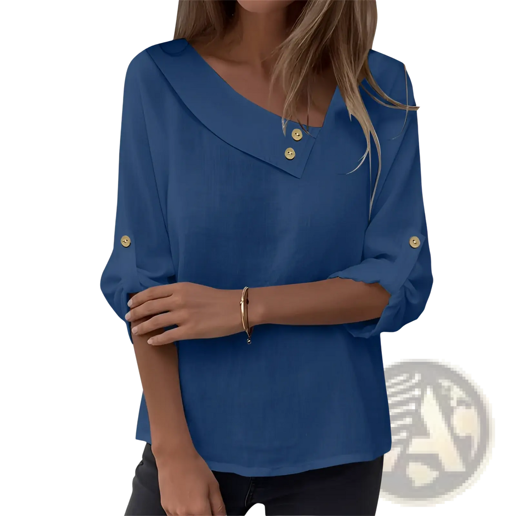 A blue long-sleeved asymmetric button blouse with v-neckline and gold buttons at collar and cuffs