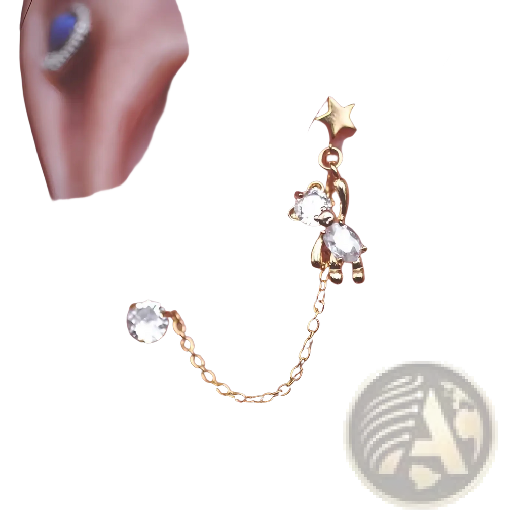 Gold-toned asymmetrical star and bear charm ear cuff with clear crystal accents and rhinestone tassel details