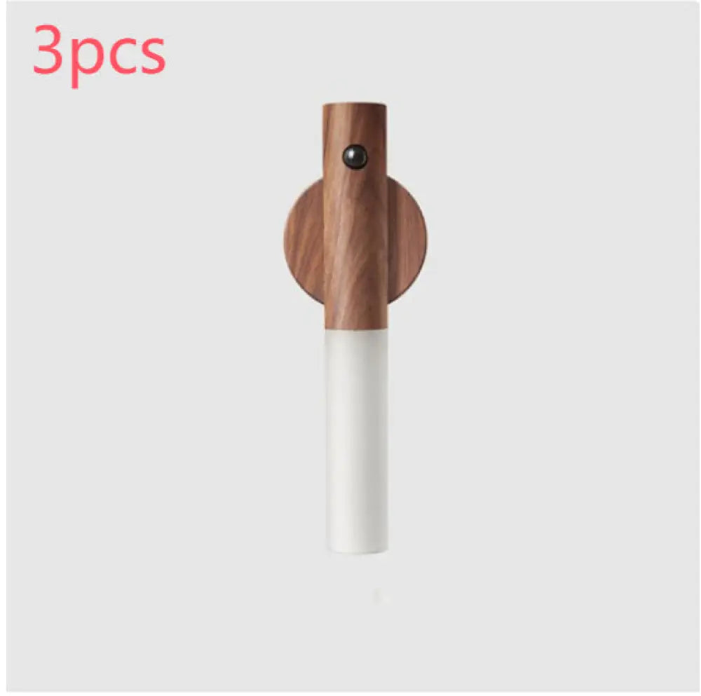 Minimalist magnetic wooden motion sensor LED night light with white cylindrical body and circular wood base wall-mounted