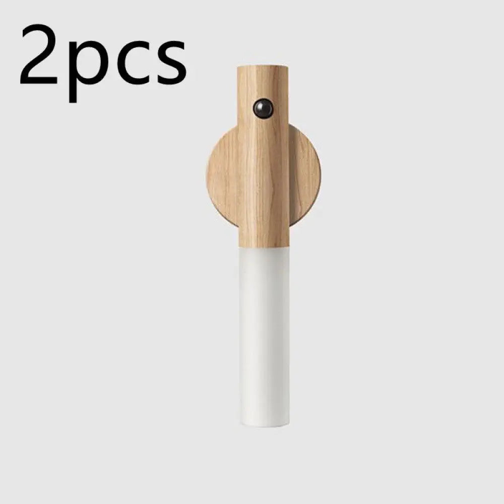 Minimalist magnetic wooden motion sensor led night light with a white cylindrical sensor and circular wood base mounted on wall