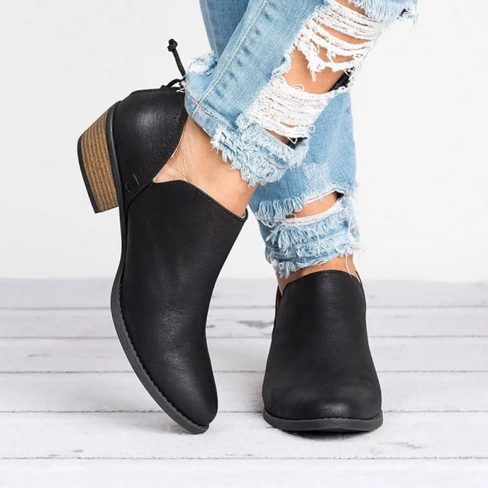Black leather ankle boots with a low block heel and lace-up back shown from the back side