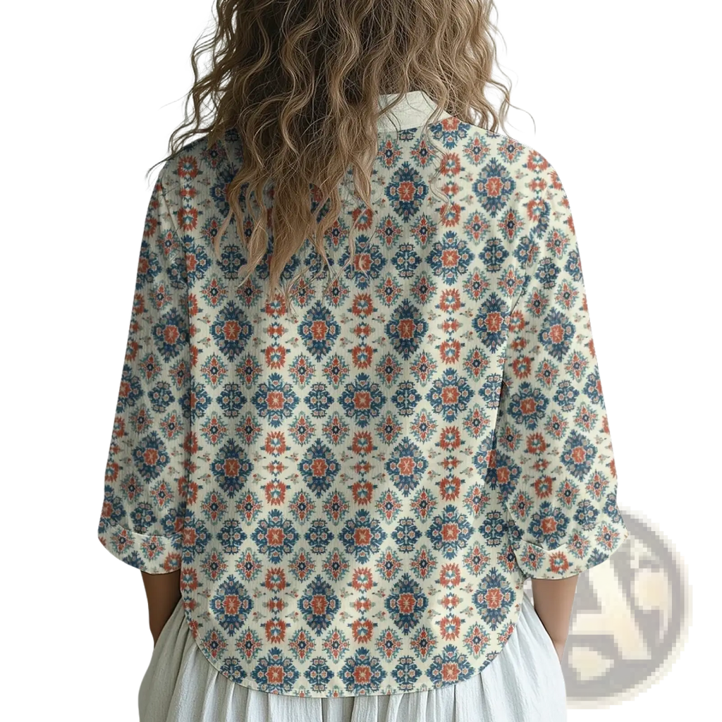 A woman wearing an Aztec geometric button up shirt with loose three quarter sleeves in blue and terracotta on cream