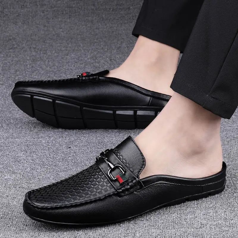 Men’s black leather mule loafers with woven texture and metallic horsebit buckle featuring red and green accents.