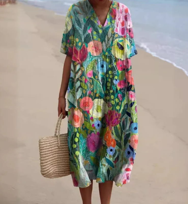 A vibrant floral v-neck short sleeve maxi dress featuring a flowing print in shades of green, pink, orange, and blue.