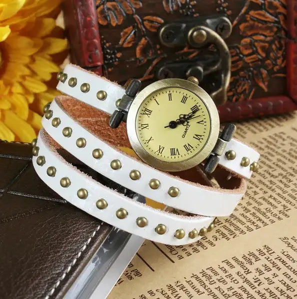 White leather wrap watch bracelet with gold-tone studs and vintage-style round face.