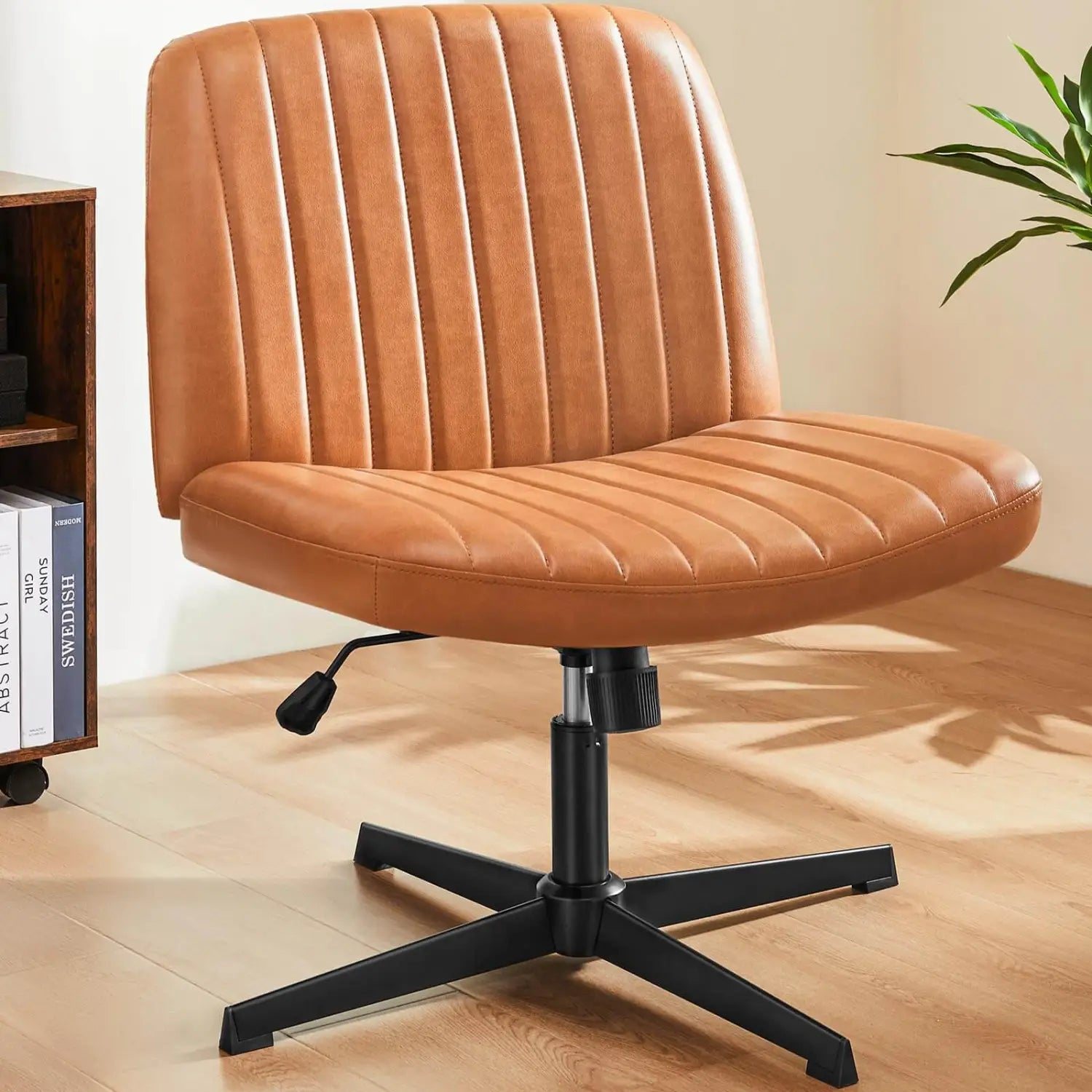 Chaise de bureau en cuir camel, à assise croisée, avec coutures verticales sur le dossier et l’assise, montée sur une base noire à cinq branches, conçue comme chaise de bureau pivotante large et sans accoudoirs.