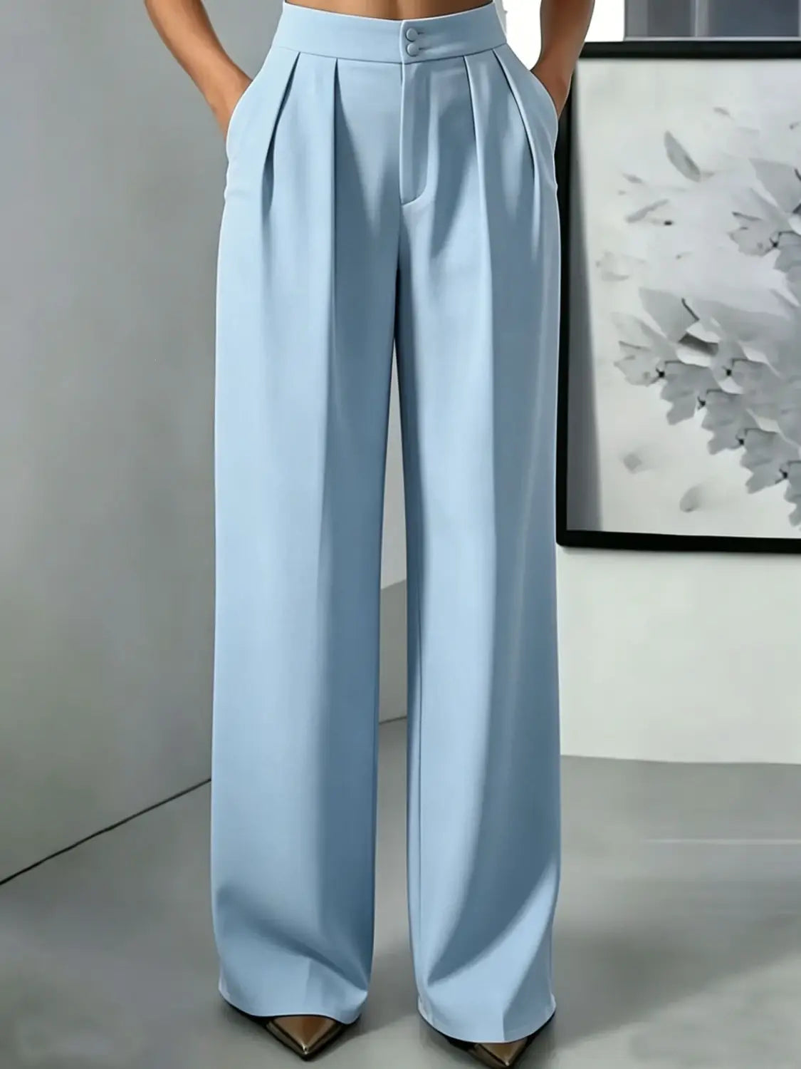Pantalons bleu clair à jambes larges et taille haute avec un design plissé élégant et une fermeture à boutons, pour une tenue stylée et confortable.