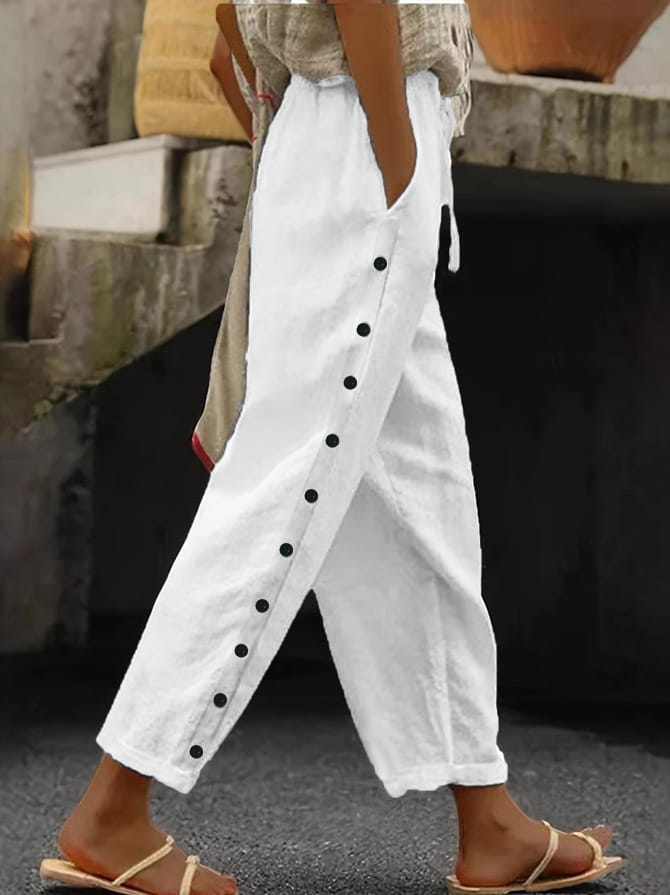 White linen cropped patchwork casual trousers for women with black button detailing down the side seam.