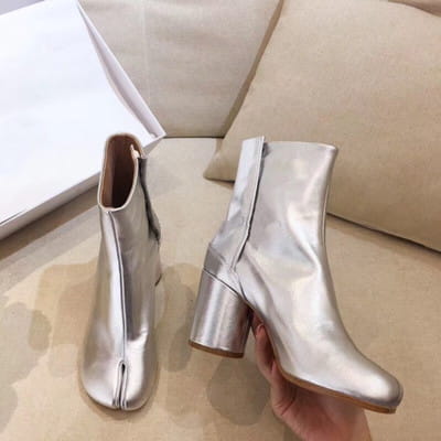 Silver metallic leather split toe tabi high heel ankle boot with chunky heel and zipper closure shown from the back side.