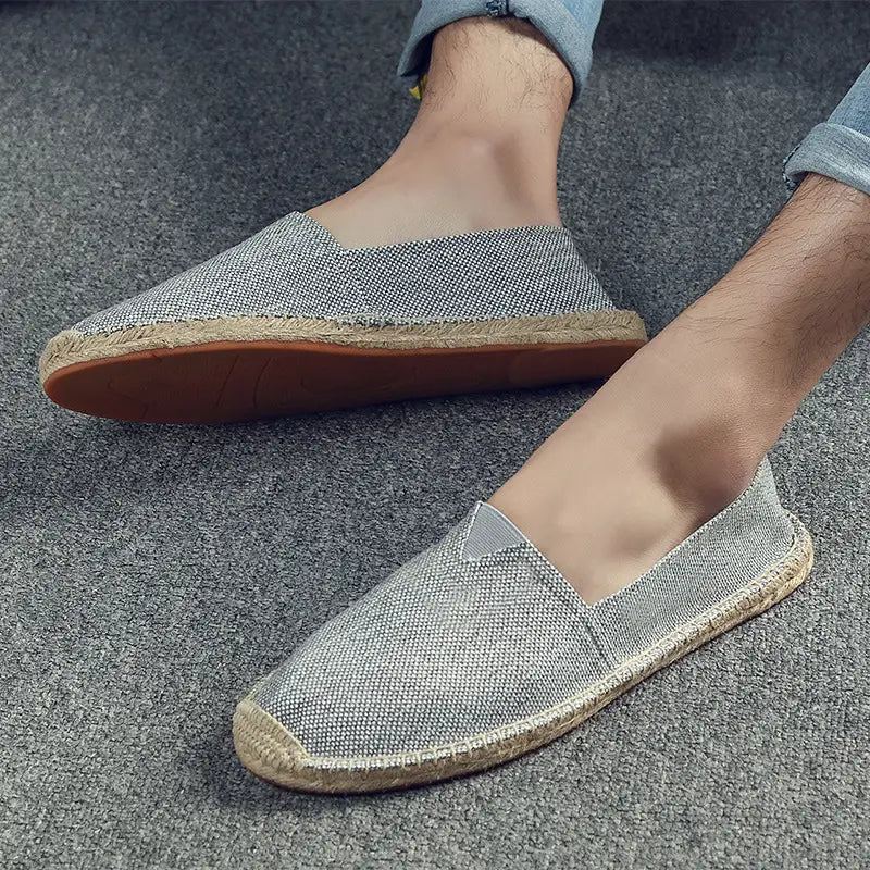Gray woven canvas espadrille slip-on shoes for men featuring a natural jute sole and tan rubber outsole ideal for summer wear.