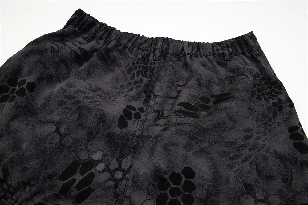 black tactical shorts with a subtle dark gray camouflage pattern featuring leaf and scale-like motifs designed as wide leg cargo pants tactical trousers.