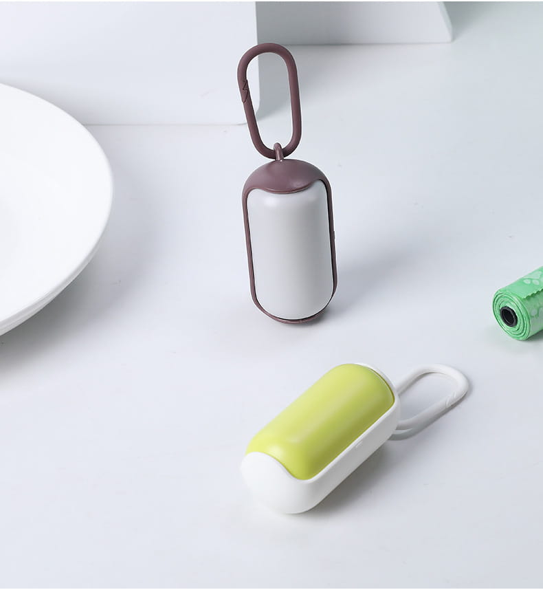 A sleek compact pet poop bag dispenser with a matte white body, brown accents, and a carabiner clip for easy attachment.