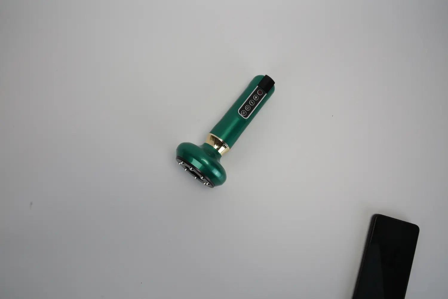 Dispositivo de masaje facial de mano color verde con acentos metálicos y una cabeza circular, diseñado para el uso como copa eléctrica inteligente de 12 niveles y masajeador para celulitis.