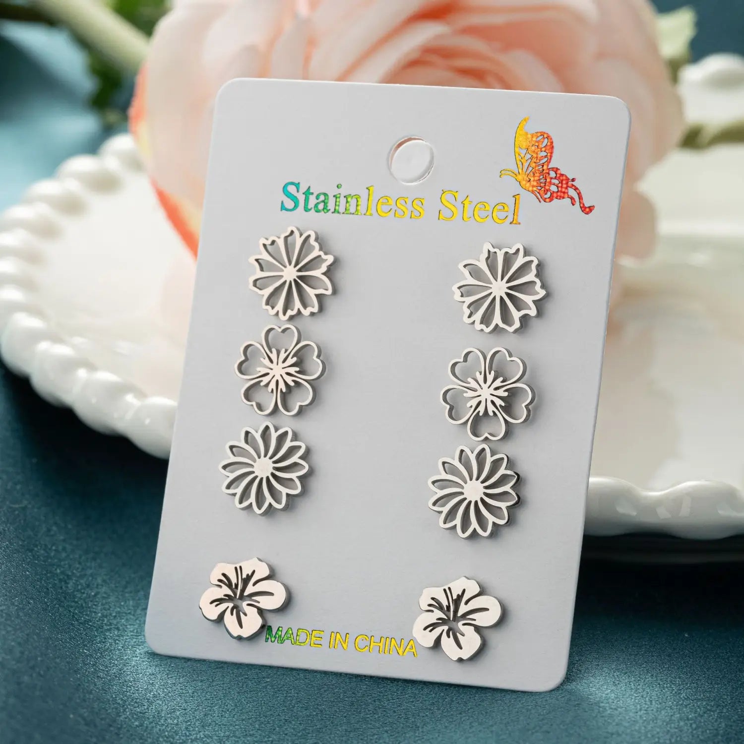 Boucles d’oreilles à clous en acier inoxydable couleur argent, en forme de fleur, issues d’un ensemble de 6 boucles d’oreilles à clous en acier inoxydable à motif floral, présentées sur une carte.