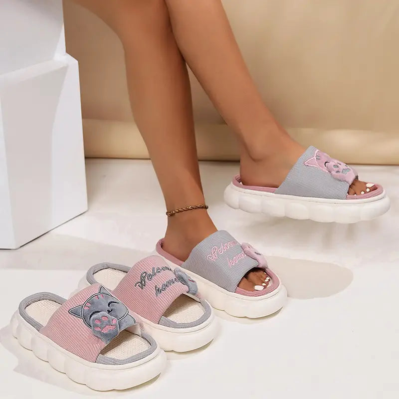 Embroided cat cartoon unisex anti slip slide slippers in pink and gray with a fluffy white sole.