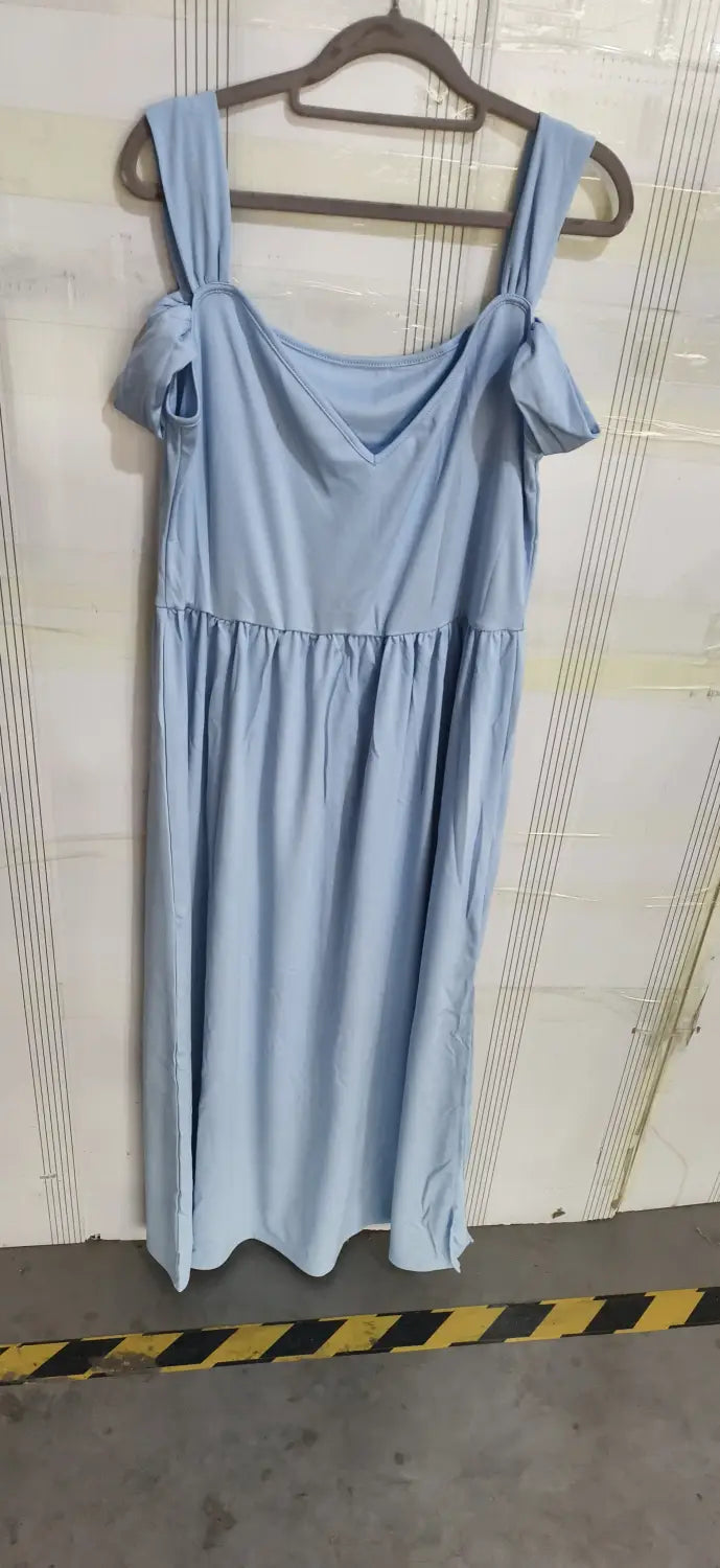 Un vestido maxi plisado floral color azul claro con diseño sin mangas, correas ajustables en los hombros y una cintura fruncida.