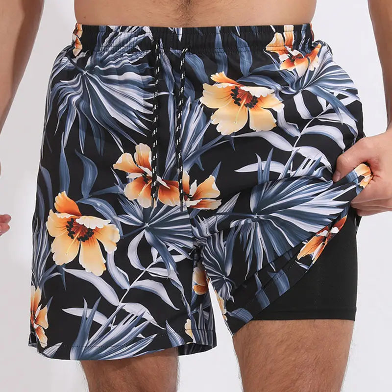 Men printed swim trunks in black featuring a vibrant tropical print with orange flowers and blue-gray palm leaves designed for sports and beach use.